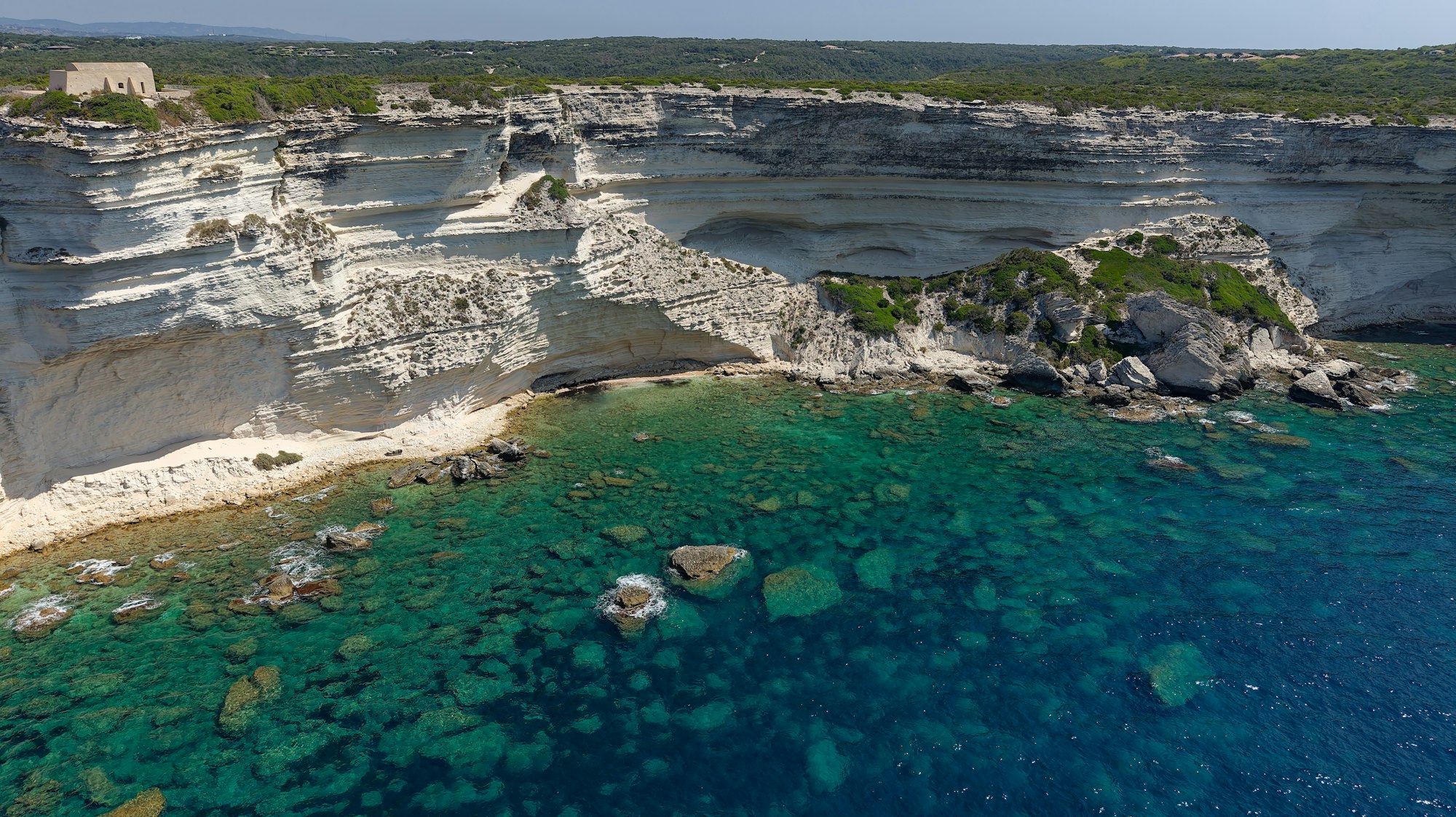 White limestone cliffs above clear turquoise water on a rocky coastline