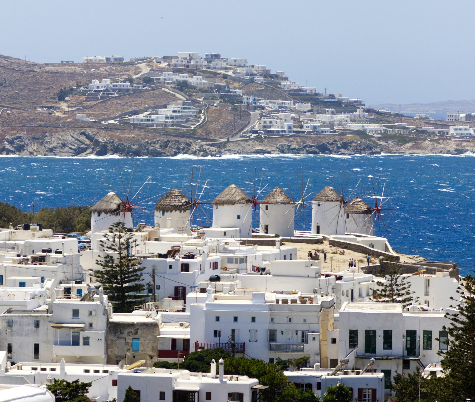 The white windmills of Mykonos on a ridge above the town